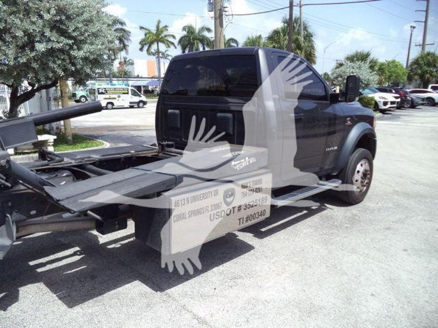 Ram 5500 rollback tow truck rear and cab with wheel on right, stock decals and towing apparatus visible.