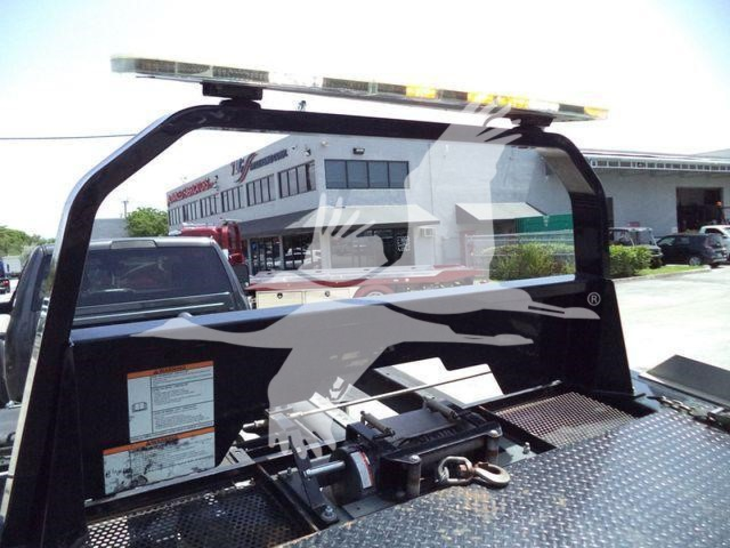 Truck bed area of a 2022 Ram 5500 SLT rollback truck showing metal diamond plate surface and tie-downs.