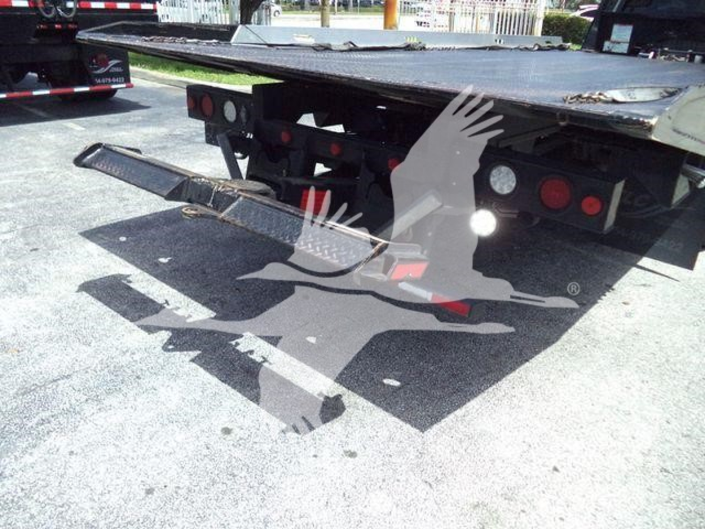 Ram 5500 rollback truck rear platform and ramps with tail lights and hitch visible.
