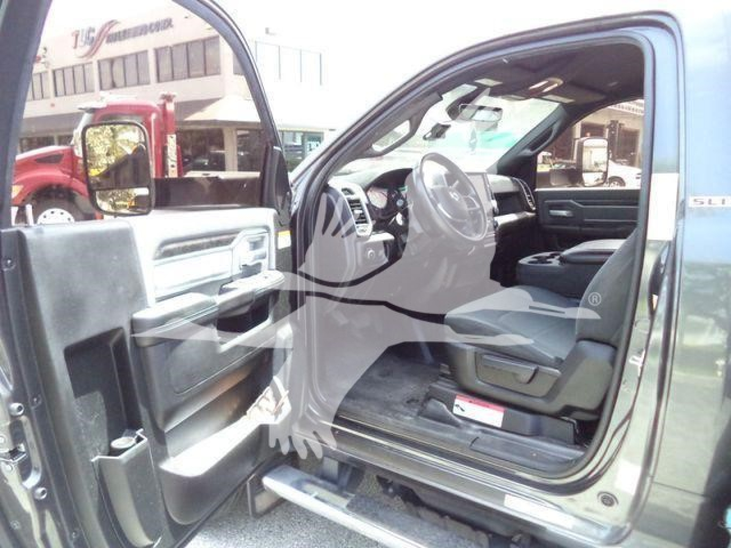Ram 5500 SLT cab interior view with front door open showing steering wheel, dashboard, and seating.