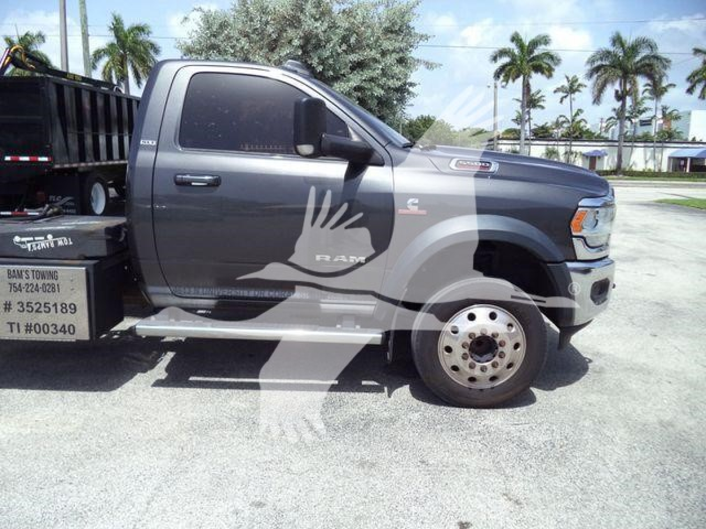 Ram 5500 tow truck side view showing cab and front wheel with RAM logo