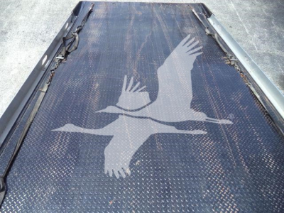 Truck bed with diamond plate surface and a large graphic of two birds in flight.