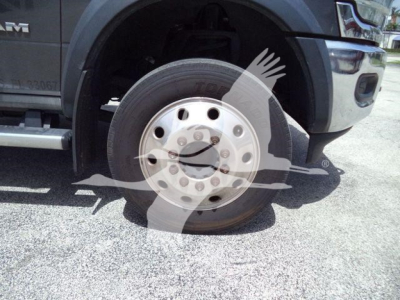Ram 5500 front wheel and fender view showing alloy wheel and tire on rollback truck with Ram badge font.