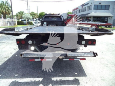 Ram 5500 rollback truck rear view showing flatbed, taillights, and rear bumper with light bars.
