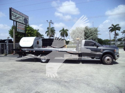 Ram 5500 SLT rollback truck with flatbed and crane, side view.
