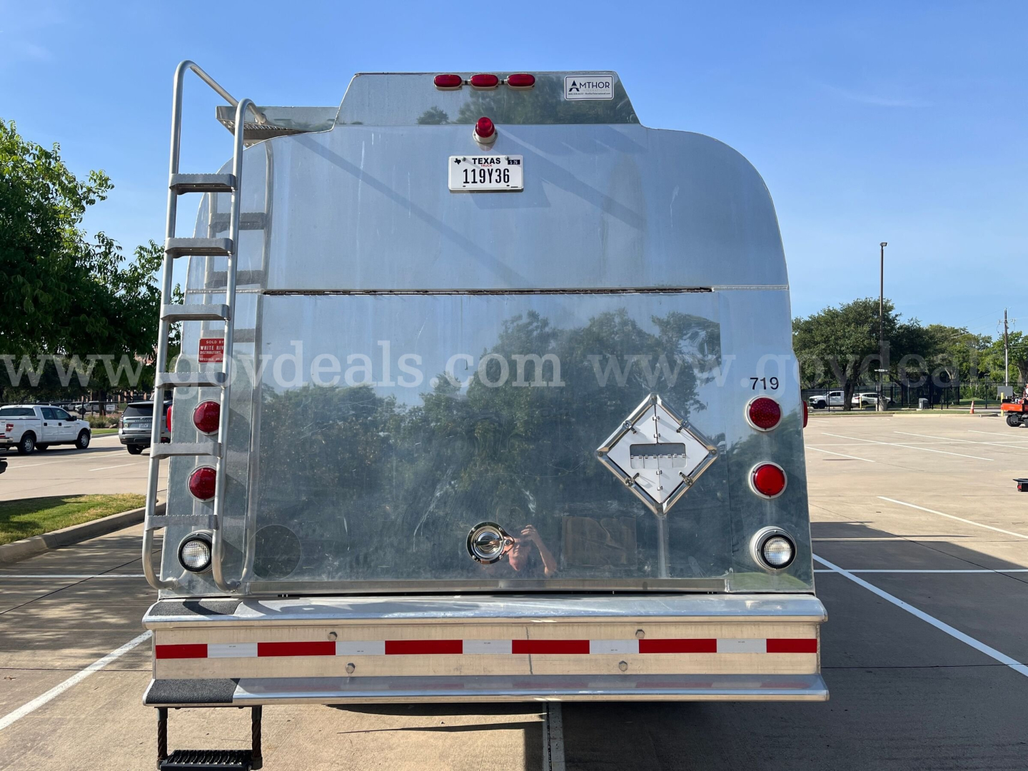 Kenworth T370 service truck rear showing diamond hazardous label and ladder on left, with tail lights and bumper.