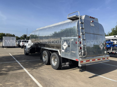 Truck trailer tanker rear and side view showing polished aluminum tanker with rear ladder, safety decals, and multiple axles.