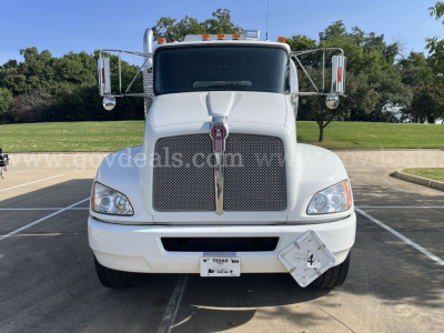 Front view of a white Kenworth T370 service truck showing grille with Kenworth emblem, large headlights, side mirrors, and a diamond plate hazard plate on the bumper area.