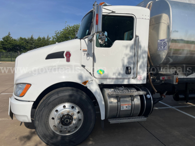 Kenworth T370 cab and fuel tank in-service truck with chrome exhaust, front wheel, and VIN plate visible on door.