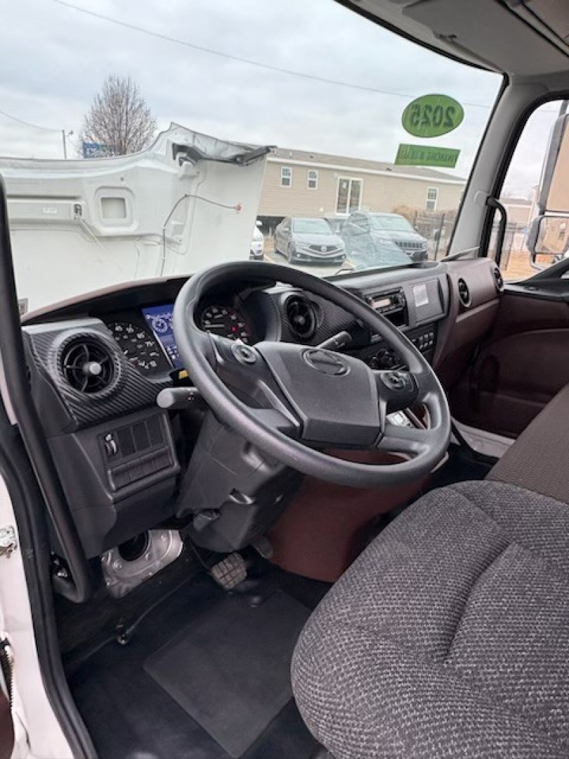 Truck cabin interior showing steering wheel, dashboard, and driver seat of a 2025 Hino L7.