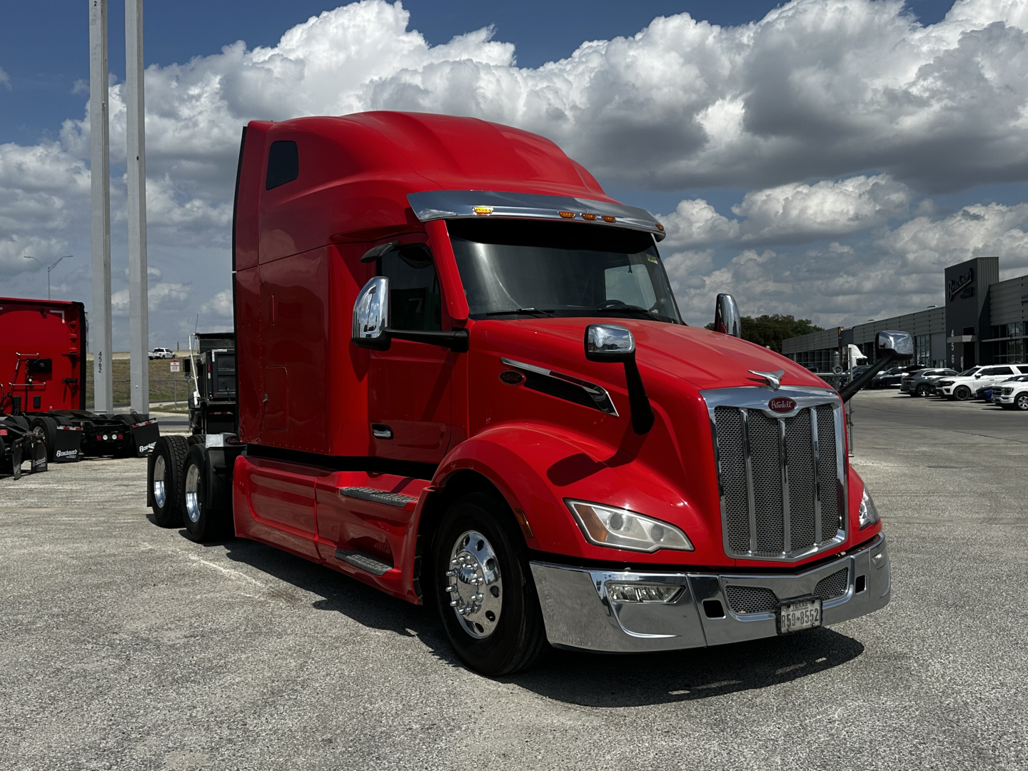 Peterbilt 579 truck in red exterior angled view showing front grille and sleeper cab.