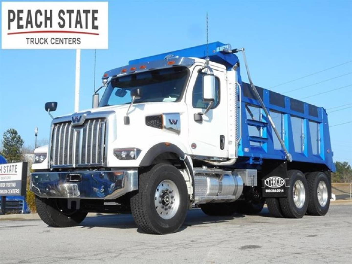Western Star 47X dump truck showing front and side profile with blue dump body and Peach State Truck Centers sign
