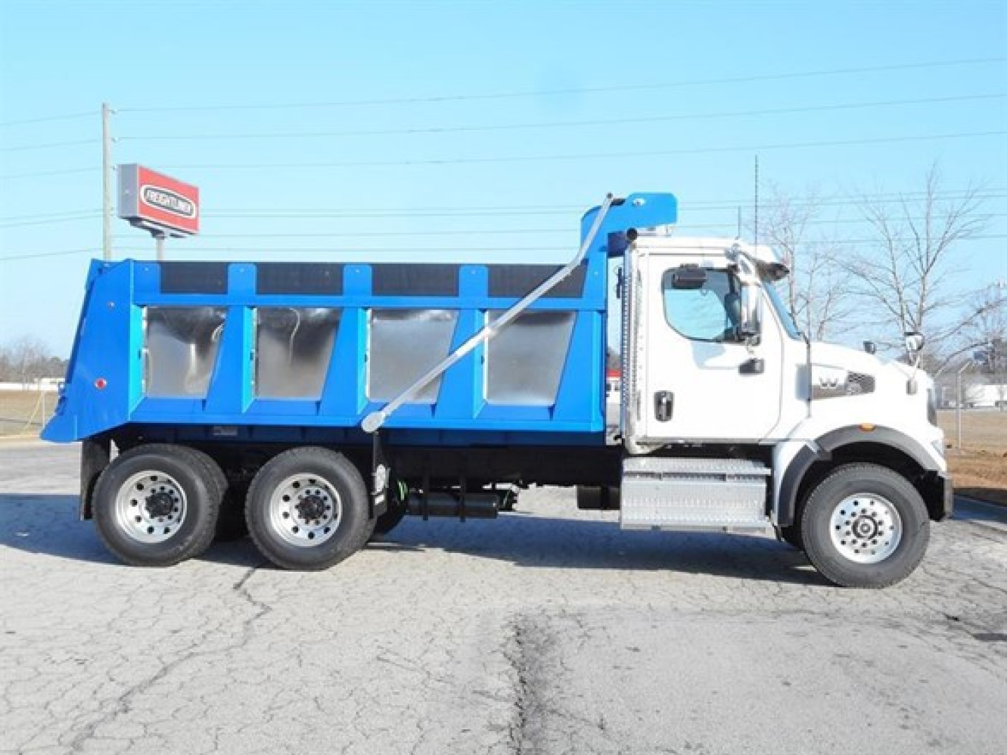 Dump truck side view showing blue dump body attached to white cab, Western Star 47X, VIN 5KKHBPDVXTLWG0457, stock 315686.