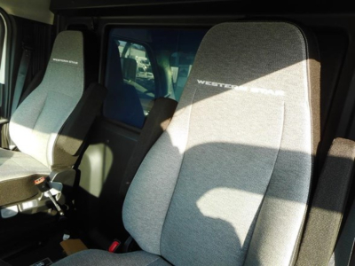Truck cab interior showing light gray cloth seats with 'WESTER STAR' branding on headrests and door area visible.