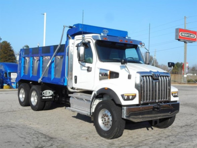 Western Star 47X dump truck in white cab with blue dump body, front grille and headlights visible.