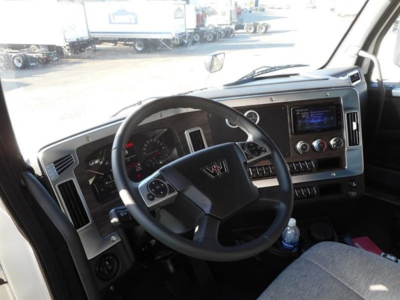 Interior of a new Western Star 47X truck cab showing steering wheel, dashboard, and infotainment system.
