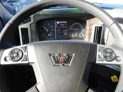 Western Star 47X truck cab interior showing steering wheel with Western Star emblem, digital instrument cluster, and controls on both sides of the wheel.