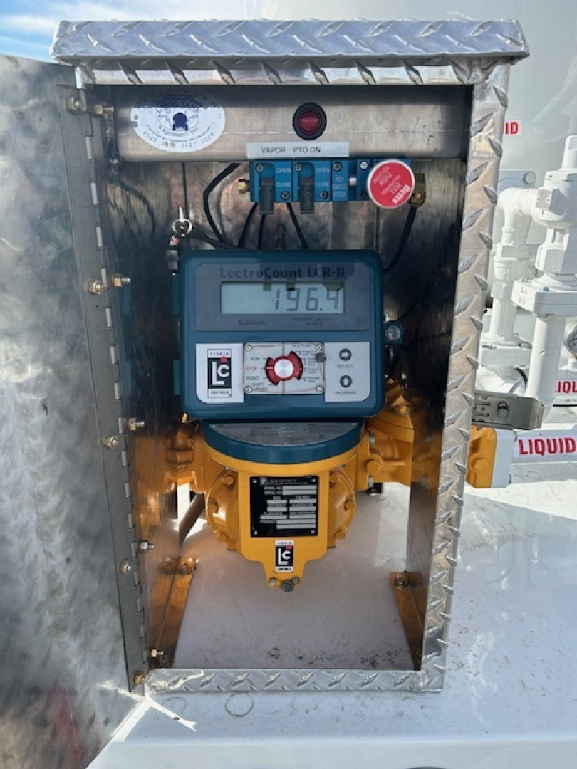Mack MD7 truck component panel with electrical meter inside a diamond-plate metal housing showing LecCount LR-1 device and blue control switches.
