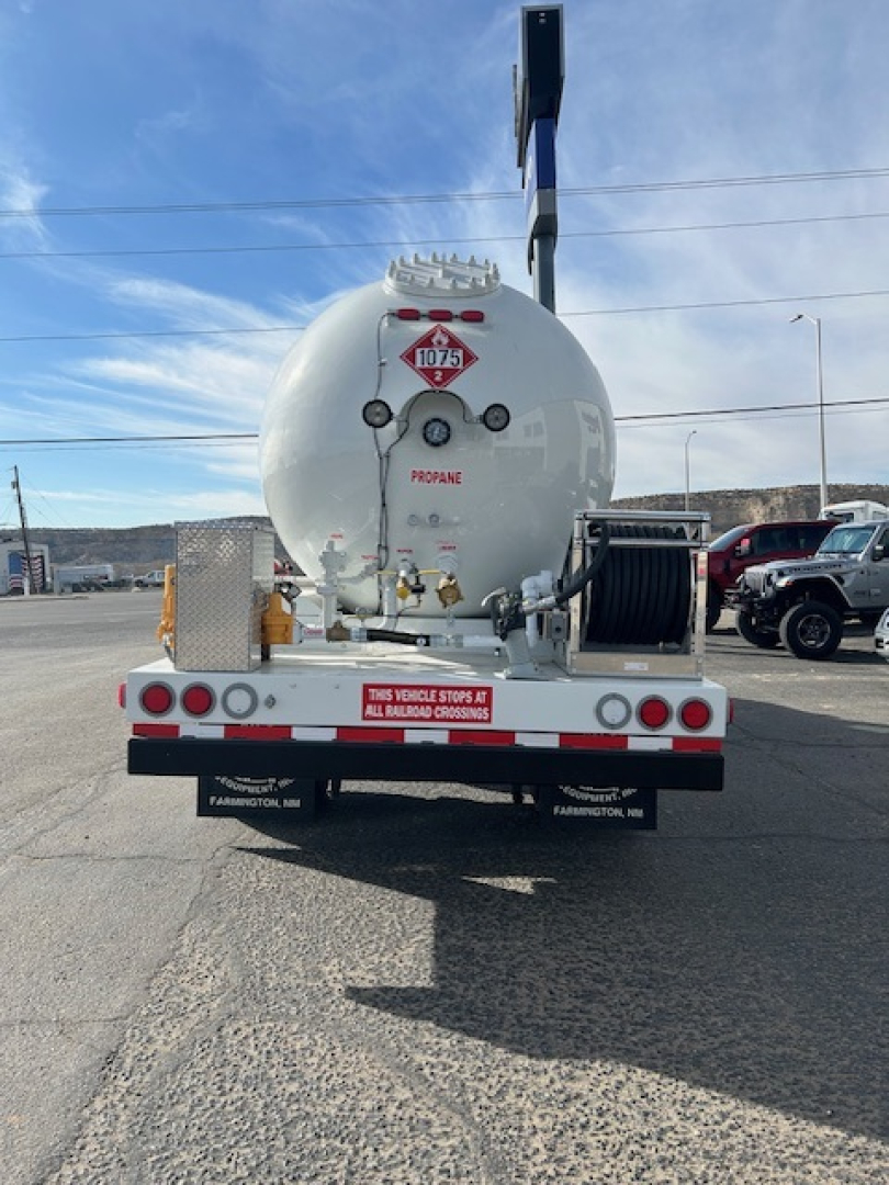 Propane tanker trailer rear showing valve connections and hazard placard 1075 on round tank.
