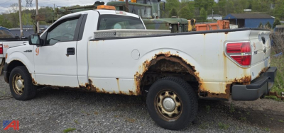 Ford F-150 XL pickup truck 2011 side view with rust around rear wheel well and cargo bed, two-tone white body, utility bed with toolbox, single cab.