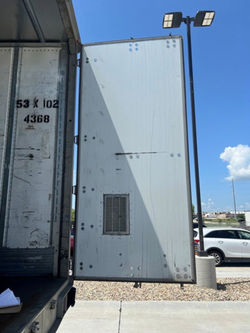 Van rear door open showing rear interior of a 2014 Utility van with metal panel and ventilation grille; text on door and trailer body not clearly legible.