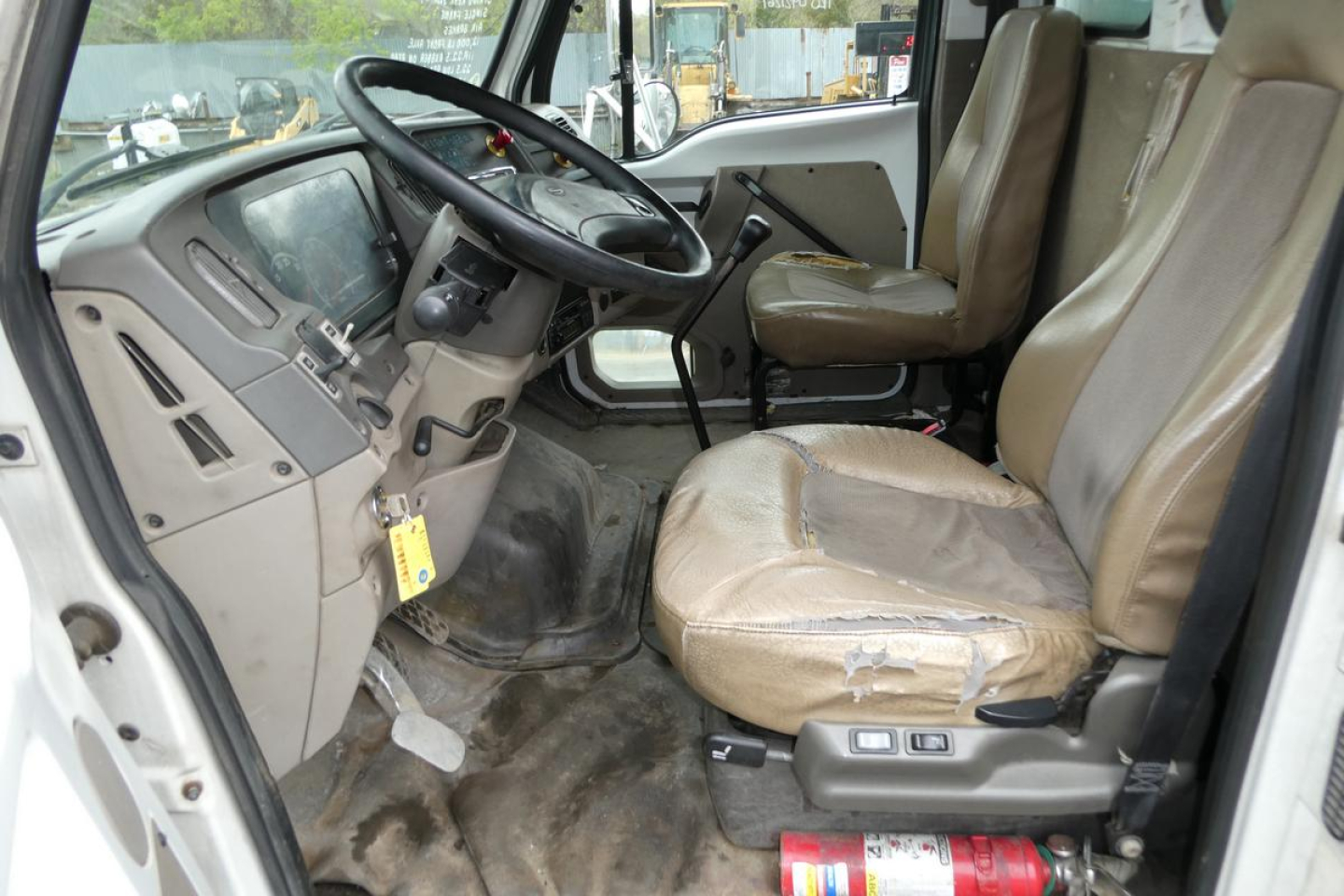 Sterling ACTERRA truck cabin interior showing steering wheel, dashboard, and front seats with worn beige upholstery.