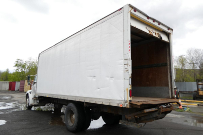 Box truck with cargo area doors open at rear, empty wooden floor, Sterling ACTERRA chassis in a used condition.