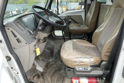 Sterling ACTERRA truck cabin interior showing steering wheel, dashboard, and front seats with worn beige upholstery.
