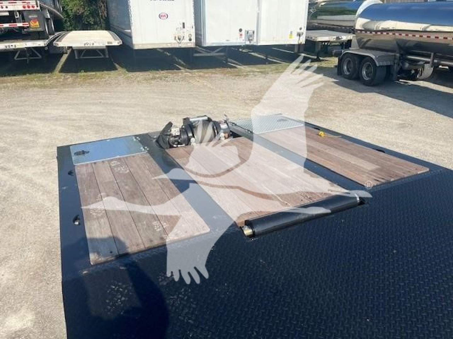 Trailer hitch area of a new XL Specialized 110Sa trailer showing a gooseneck coupler and wooden deck with diamond plate steel edges.
