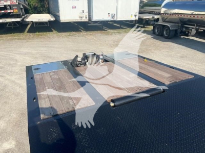 Trailer hitch area of a new XL Specialized 110Sa trailer showing a gooseneck coupler and wooden deck with diamond plate steel edges.