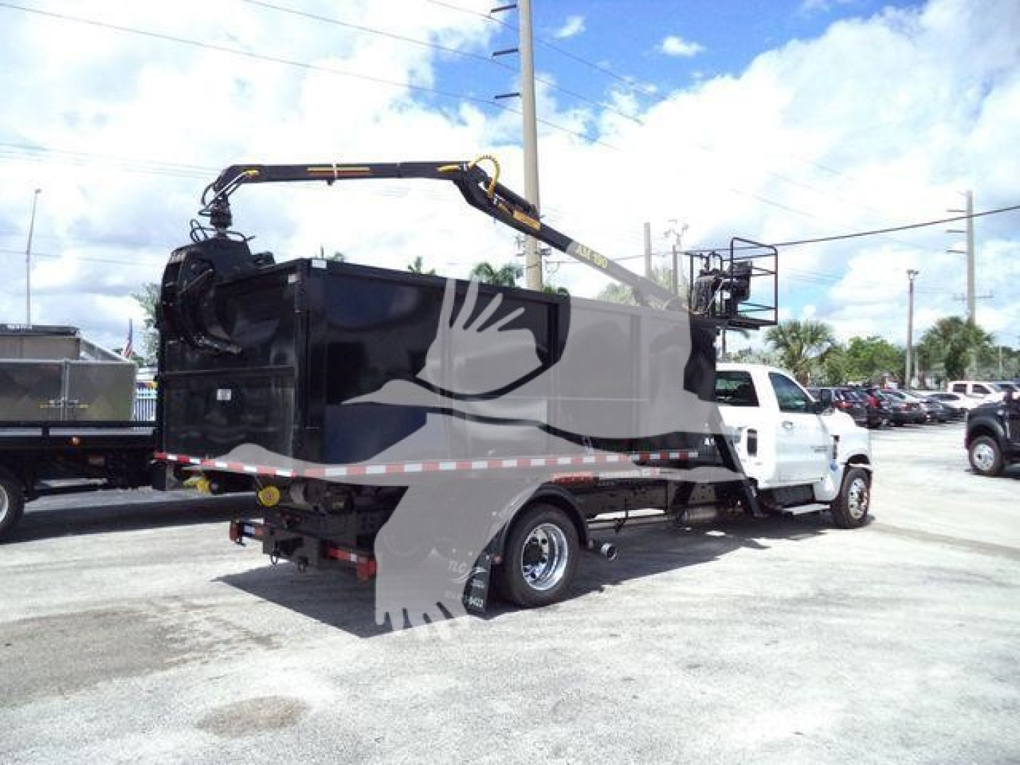 Chevrolet Silverado 6500HD chassis with hydraulic crane on a flatbed truck, side view showing rear dump body and crane arm.