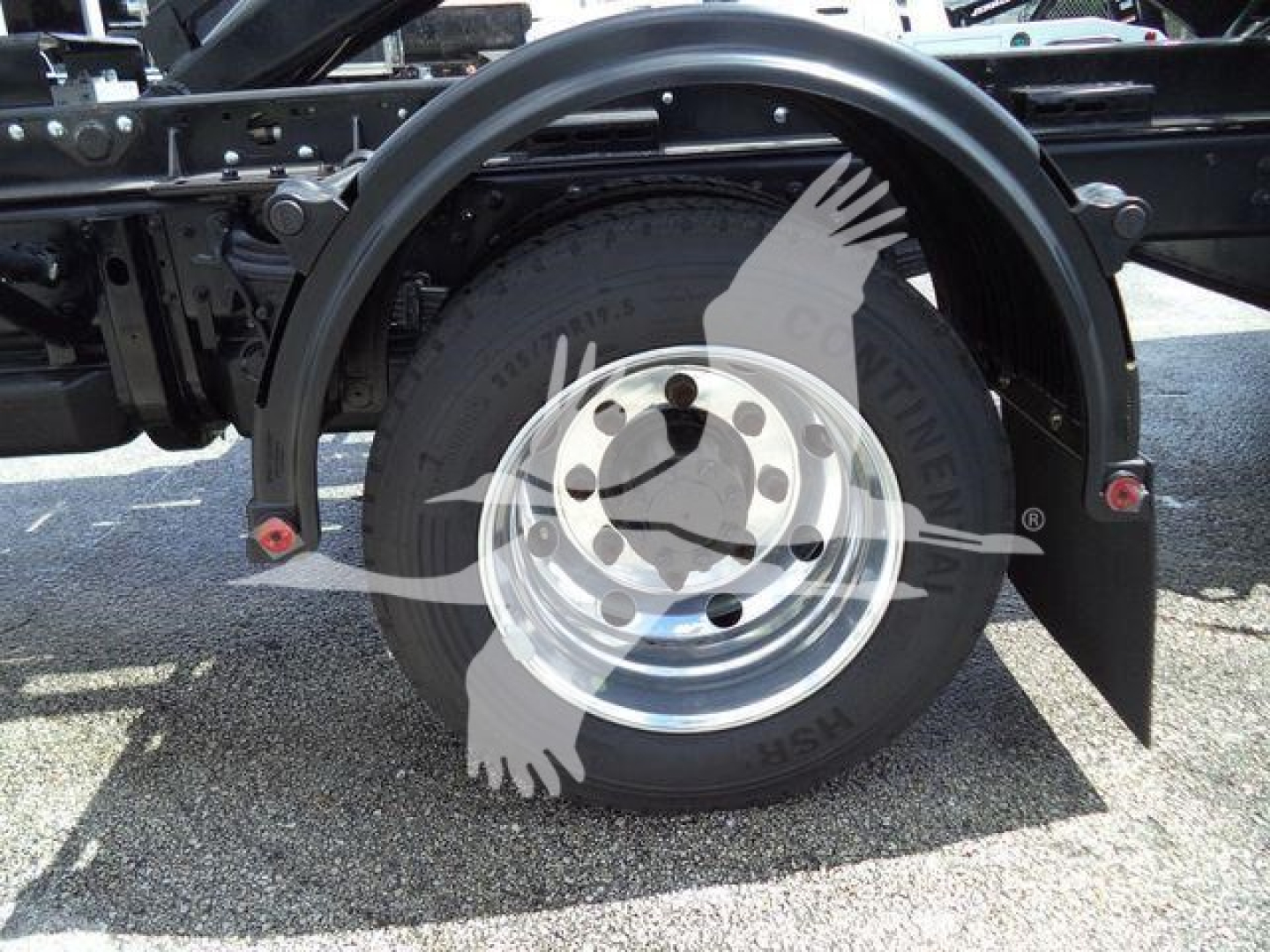 Chevrolet Silverado 6500HD truck rear wheel and fender area showing spare wheel and tire, wheel well, and frame rails.