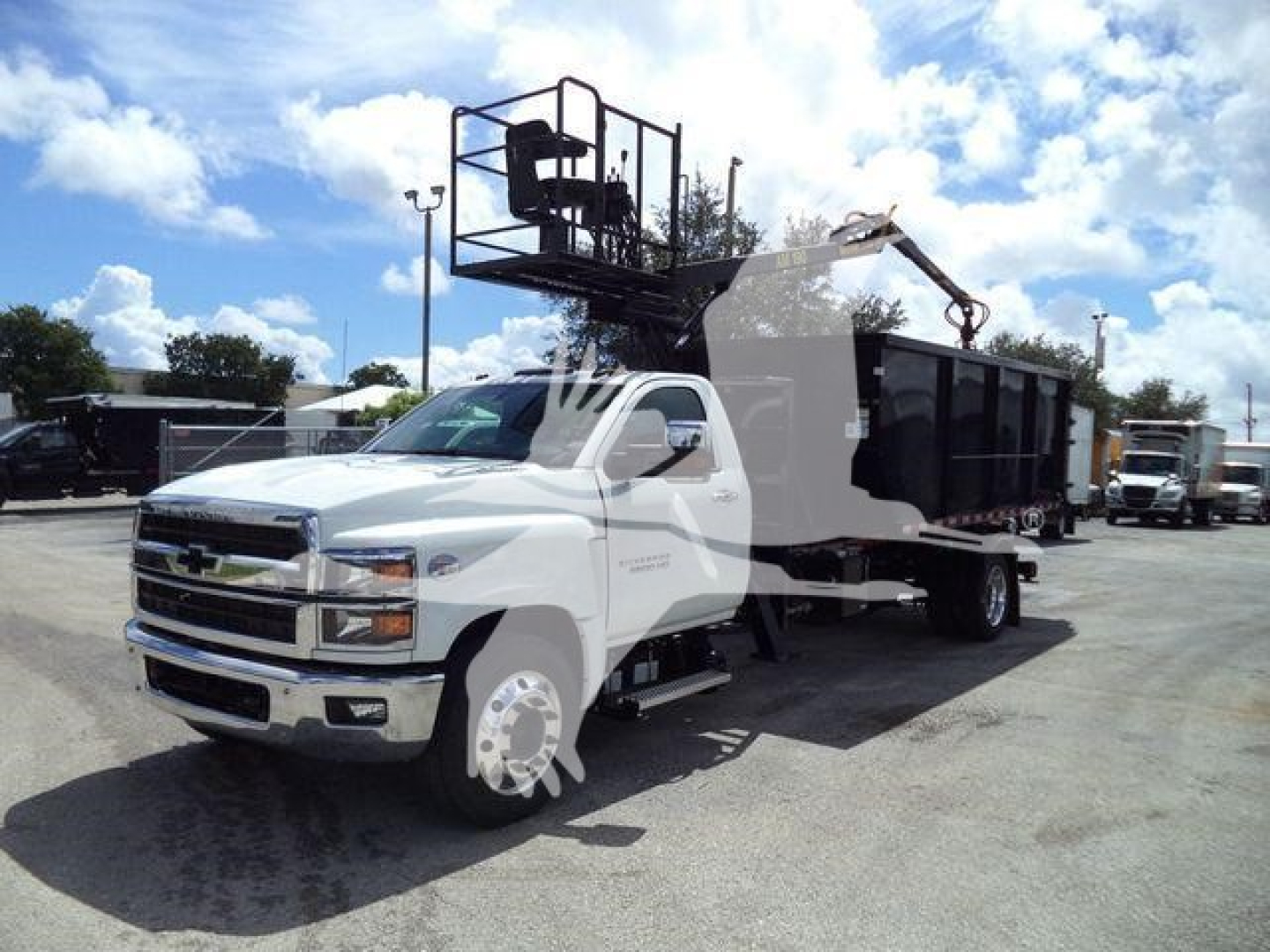 Chevrolet Silverado 6500HD truck with a large hopper/dump body in a dealership lot.