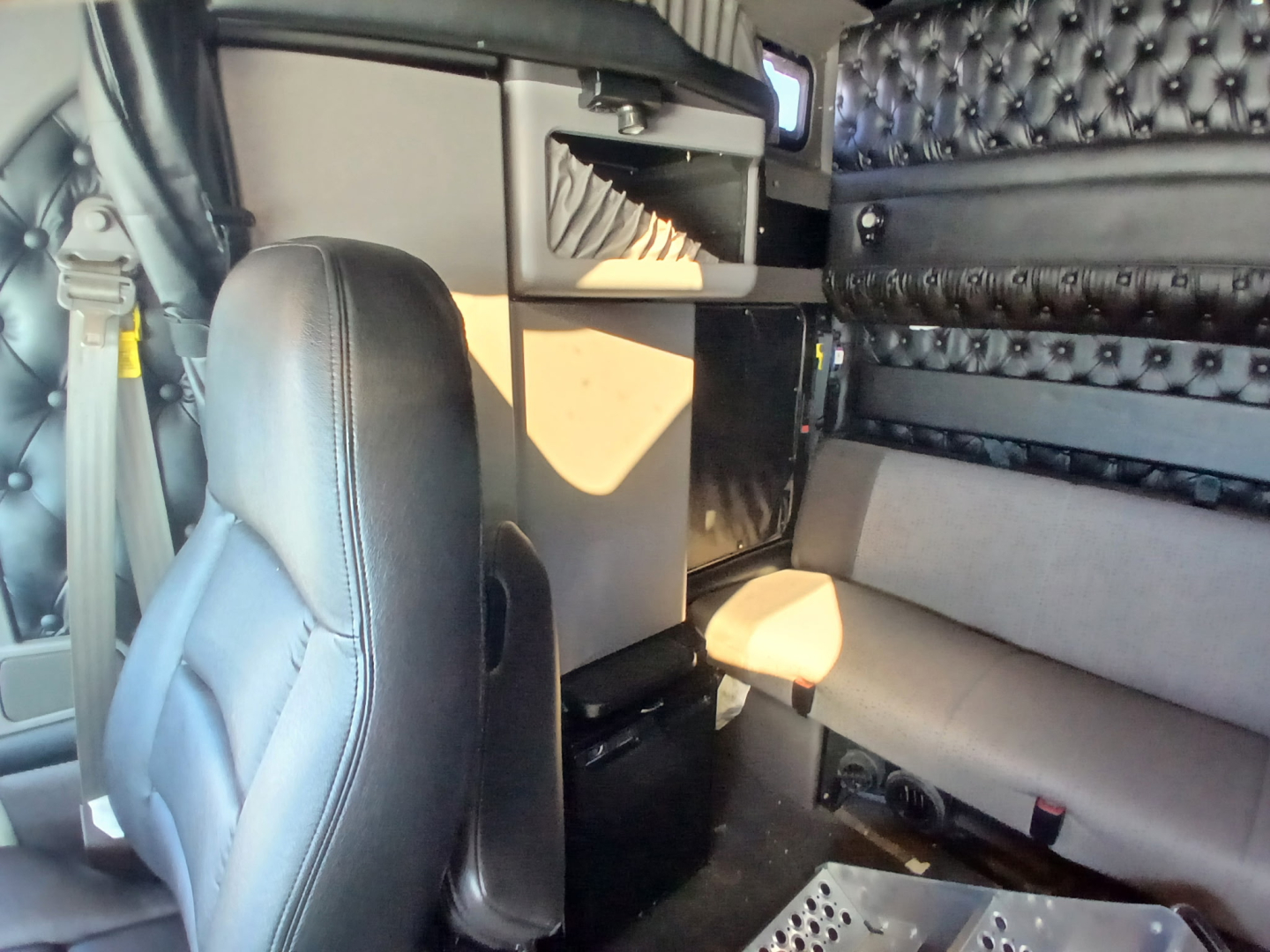 Kenworth W900L truck interior showing sleeper cab with storage cabinet and seating area
