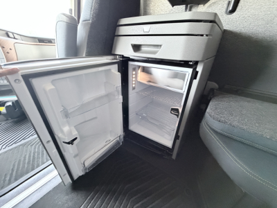 Volvo VNL64T860 cab interior showing compact side fridge and small freezer with empty shelves and door open