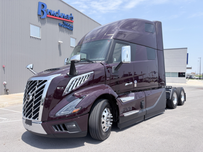 Volvo VNL64T860 model truck in a truck yard with purple paint and chrome grille