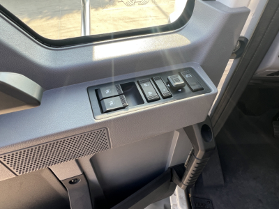 Cockpit of a 2026 Mack GR64B showing switch panel with window/lock controls and gauge cluster area.