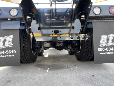 Rear view of a 2026 Mack GR64B rolloff truck showing the differential, axles, and undercarriage with mud flaps and tires visible.