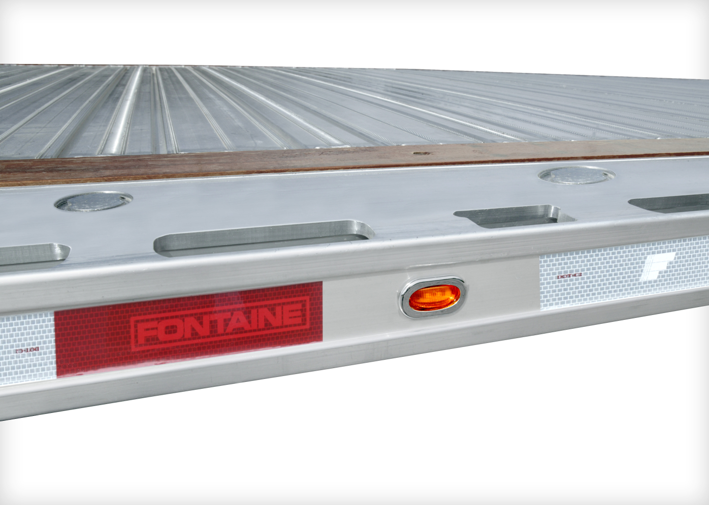 Trailer rear edge of a Fontaine flatbed showing aluminum deck and red Fontaine logo plate.