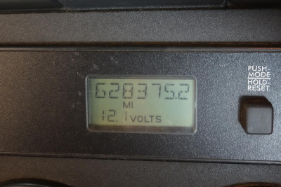Gauge display showing '62837.52 MI' and '12.1 VOLTS' inside cab area of a Freightliner Cascadia 125.