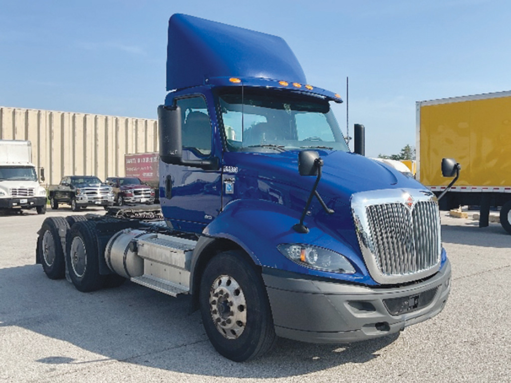 Blue 2020 International RH613 conventional daycab truck, front-left view, with high cab and dual rear axles, chrome grille and DEF/fuel tanks visible.