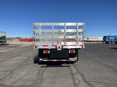 Isuzu FTR stake bed truck rear view showing metal side rails and bumper with taillights.