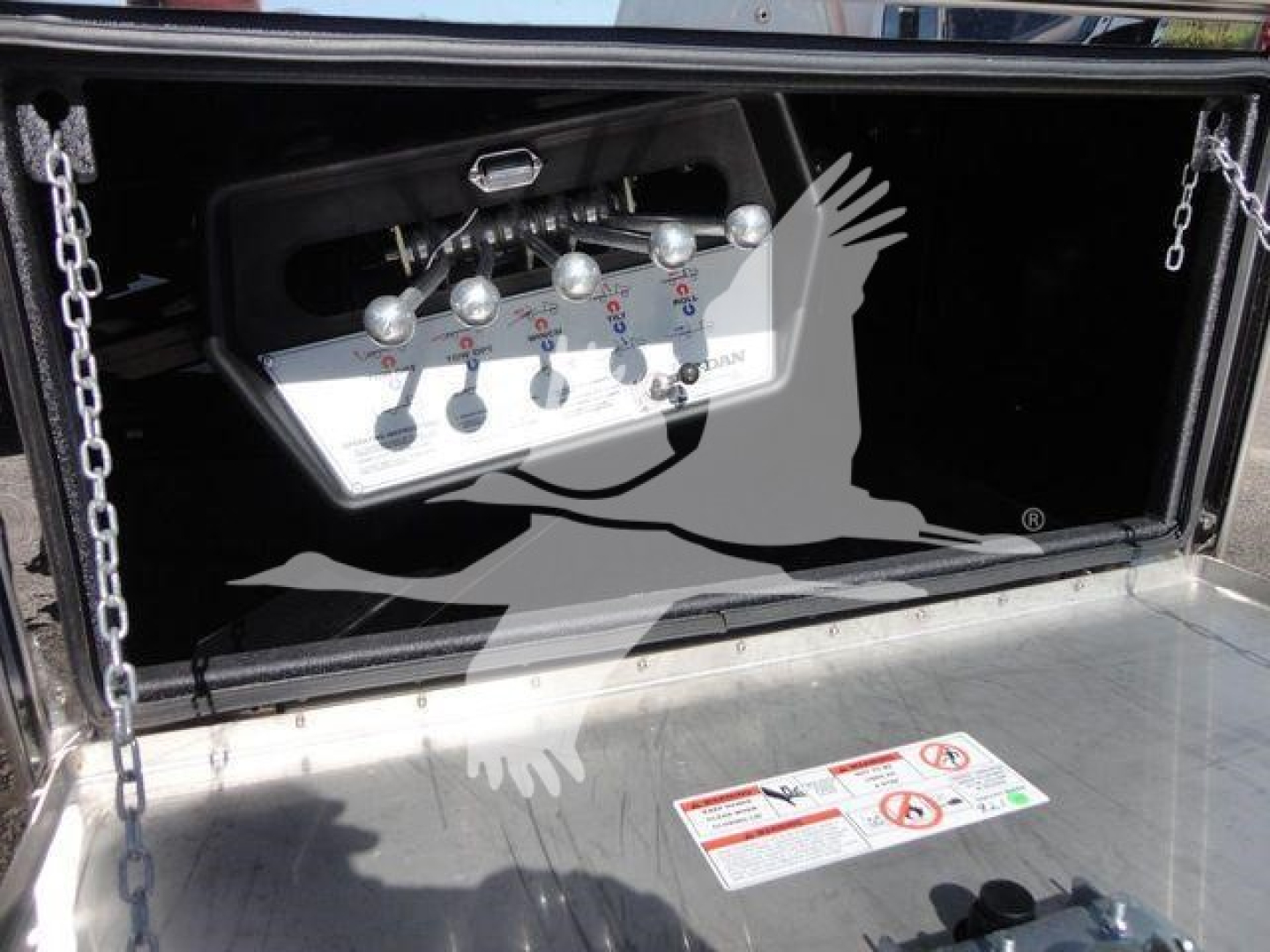Mack MD6 rollback truck control panel with levers and labels in the toolbox compartment.