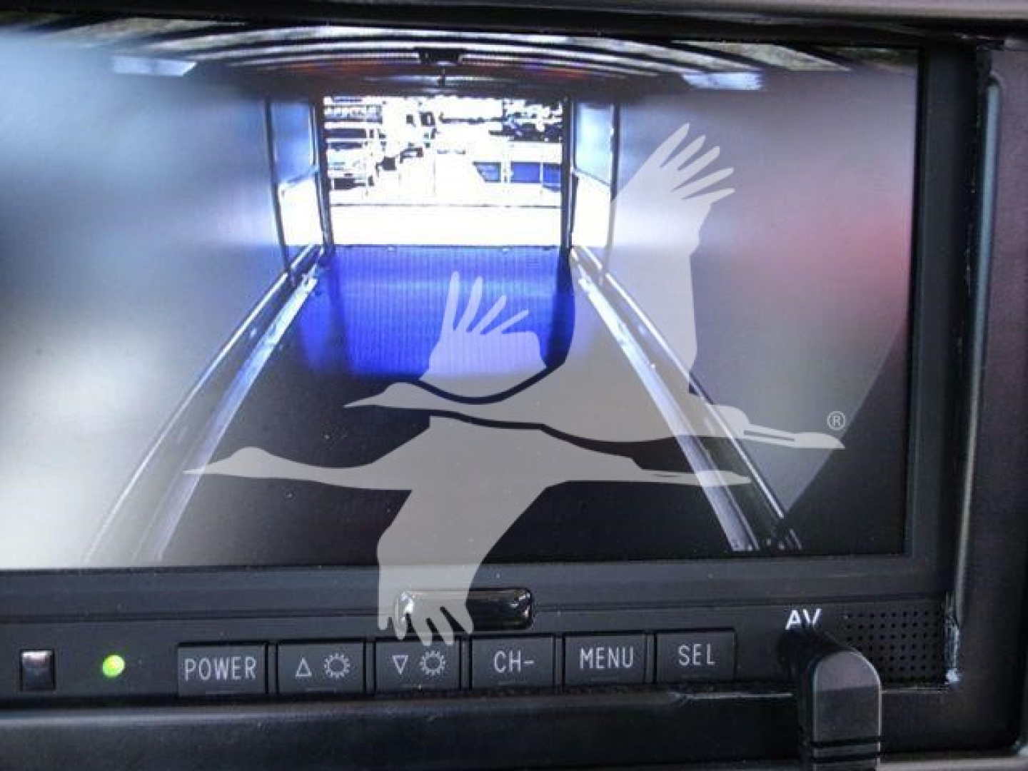 MD6 rollback truck display showing rear view camera screen with control buttons below and a delivery graphic overlay.