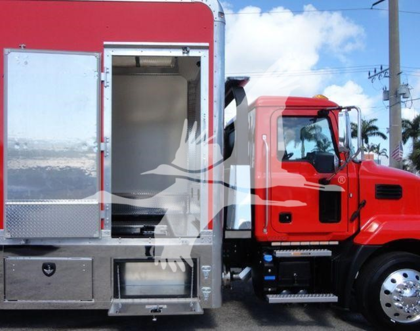 MD6 rollback truck cab and service body showing side access doors and chrome fuel tank; red cab with black grille and polished wheels.