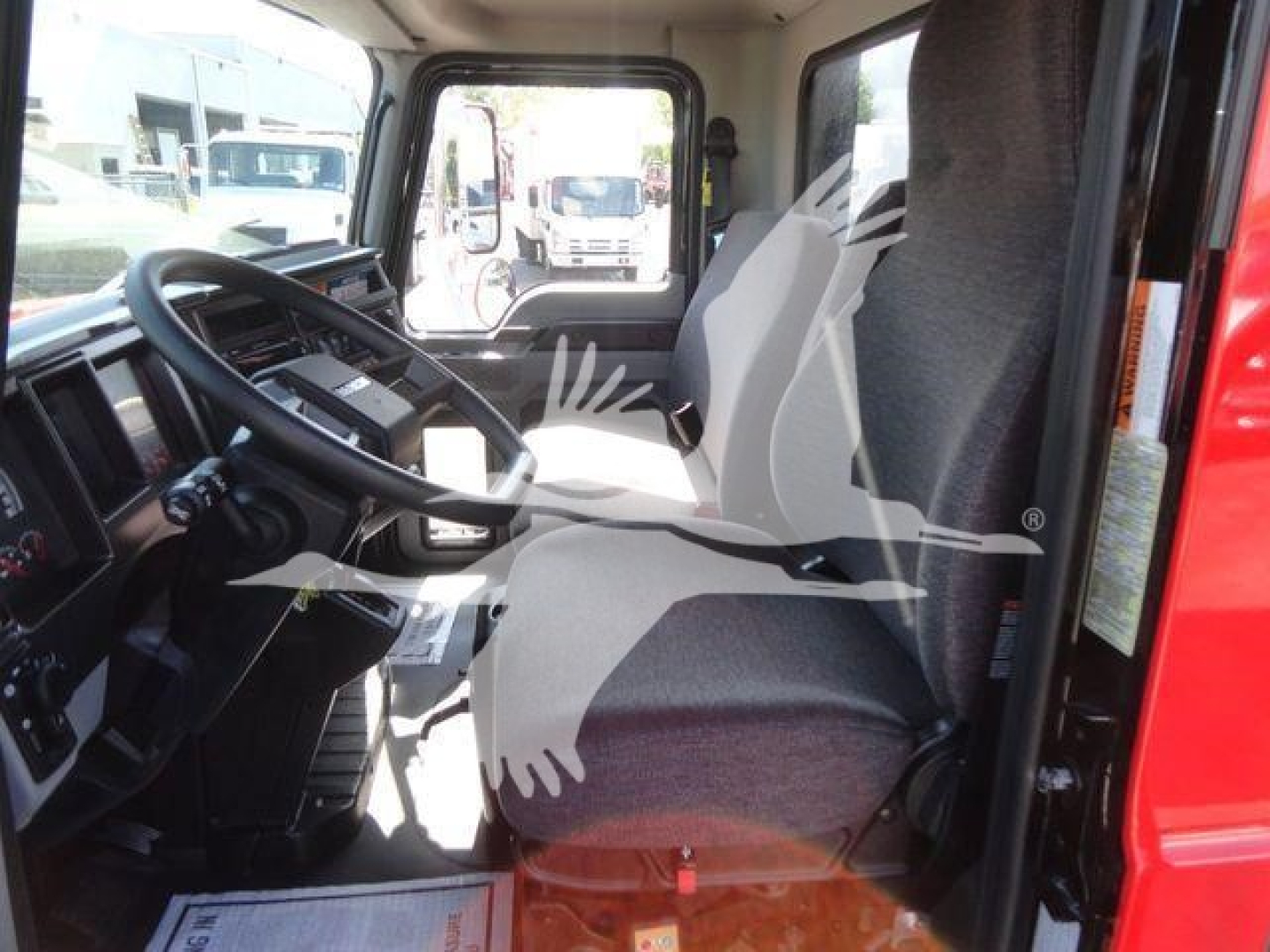 Cab interior of a 2027 Mack MD6 rollback truck showing steering wheel, driver seat, and dashboard.