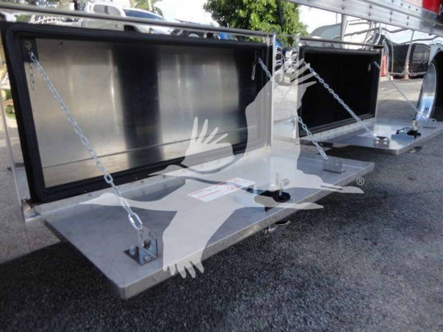 Truck bed accessory showing storage boxes on a Mack MD6 rollback chassis with chain tie-downs and metal steps.