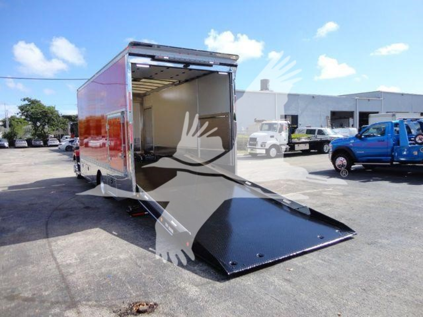 MD6 dump truck/rollback trailer with open rear ramp and loading bed showing interior cargo space and black steel ramp.