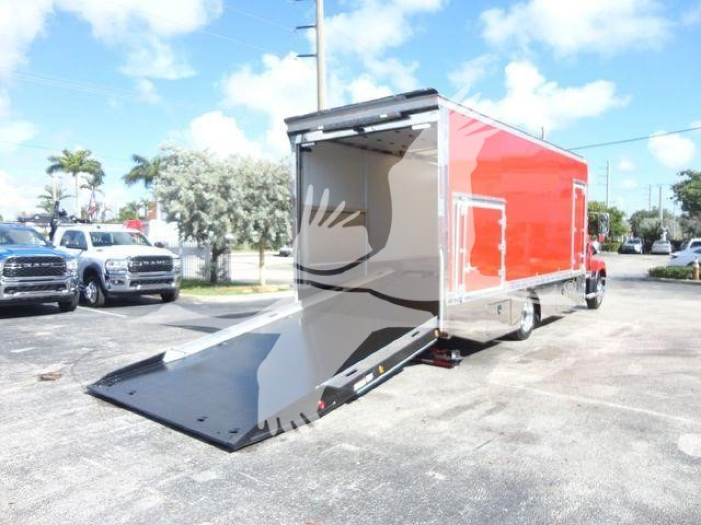 MD6 rollback truck with a red cargo box and fold-out ramp, showing a wide loading platform and side door.