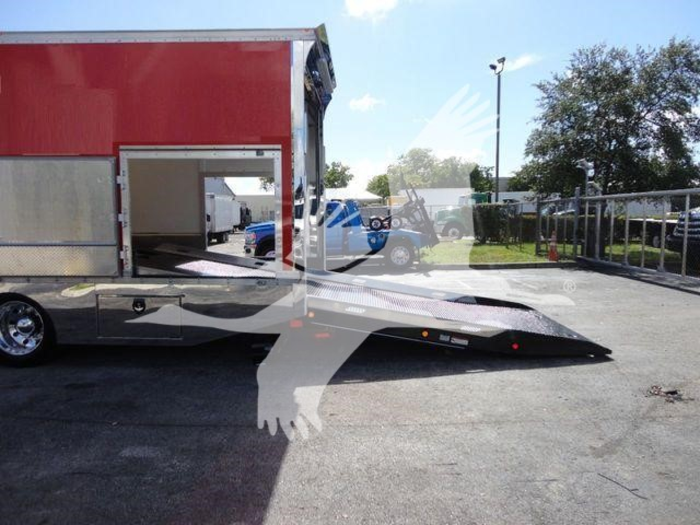 MD6 tow truck in a rollback body with ramp extended for loading, red trailer, side entry door visible.